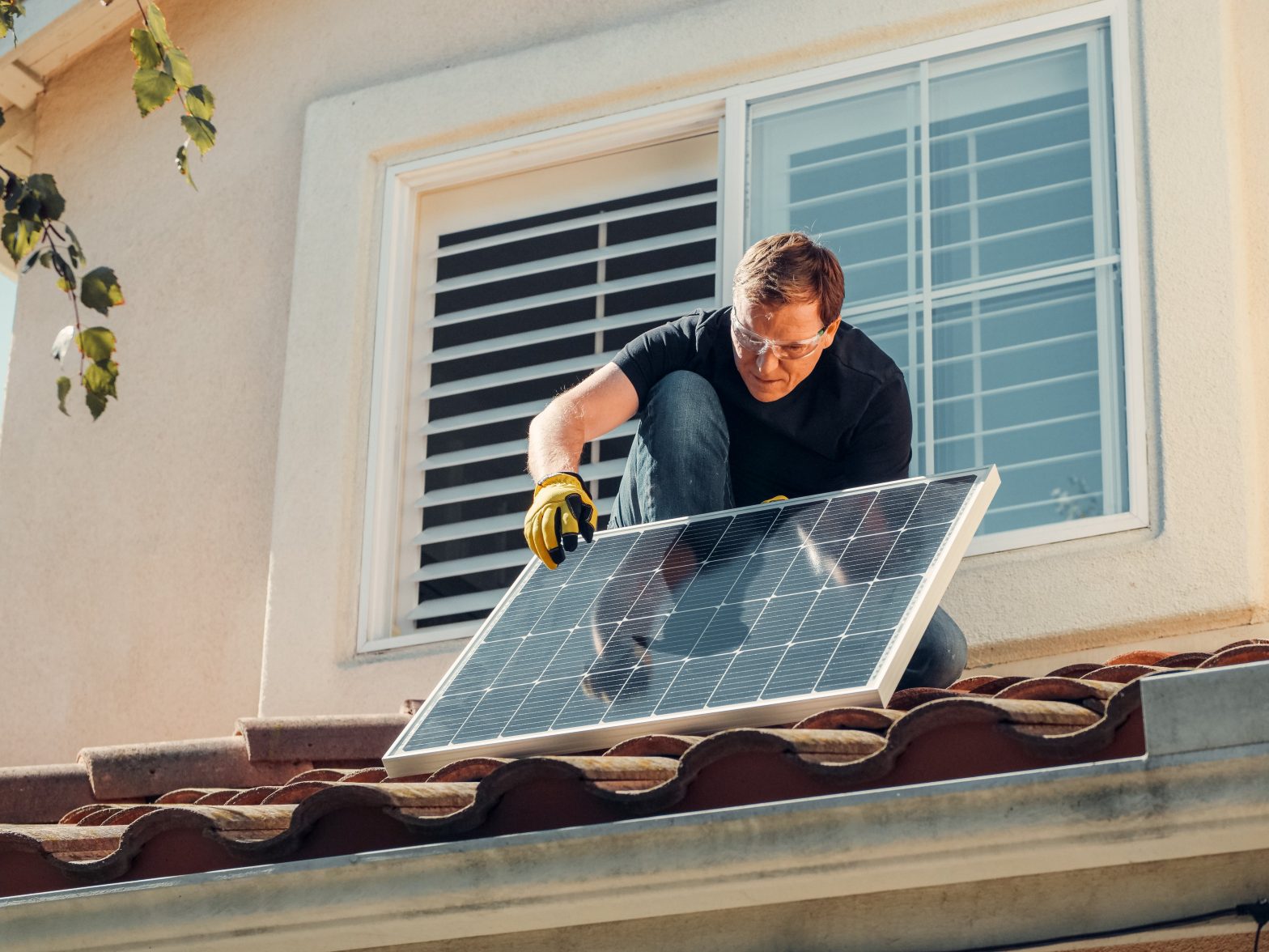 Hombre instalando plazas solares en vivienda de Cádiz